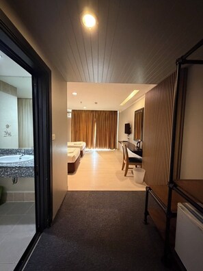 A modern hotel room with a bathroom, a desk, and a bed. - J & Y Lodge Hotel (Chonburi)