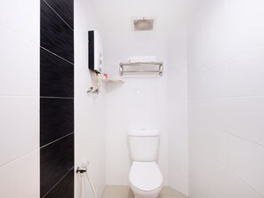 A small, modern bathroom with white tiles, a white toilet, a towel rack, and a hand dryer. - Super OYO 635 Seven Days Hotel (Raub)