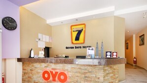 A reception desk at the Seven Days Hotel with a clock, a reception sign, and a logo. - Super OYO 635 Seven Days Hotel (Raub)