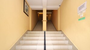 A staircase with alternating light and dark tiles, leading to a landing. - Super OYO 635 Seven Days Hotel (Raub)