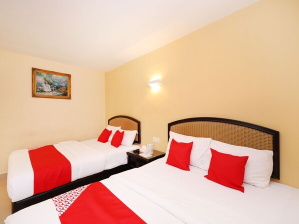 A hotel room with two beds, each with white and red bedding, a painting on the wall, and a nightstand with a lamp. - Super OYO 635 Seven Days Hotel (Raub)