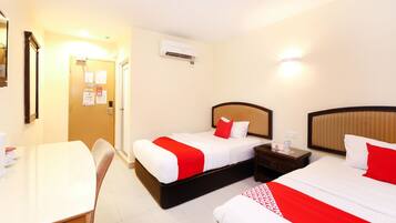 A hotel room with two beds, a desk, and a chair.