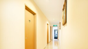 A hotel corridor with doors, a sign for the lobby, and a framed picture on the wall. - Super OYO 635 Seven Days Hotel (Raub)