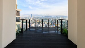 A balcony with a city view, featuring a glass railing and a wooden floor. - J DUPION Boutique Suites by NowHere (Kuala Lumpur)