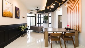 A modern dining area with a wooden table, chairs, and a ceiling fan. - J DUPION Boutique Suites by NowHere (Kuala Lumpur)