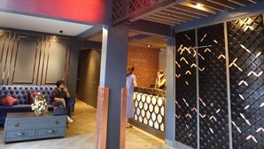 A hotel lobby with a modern design, featuring a prominent neon sign, seating areas, and a reception desk. - Ratchada Boutique Hotel (Bangkok)