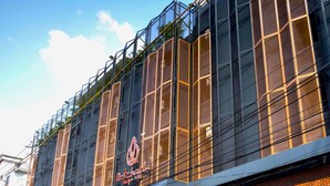 A building with a modern facade, featuring large windows and a prominent logo. - Ratchada Boutique Hotel (Bangkok)