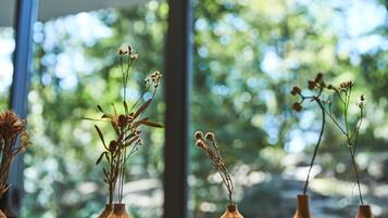 Four wooden vases with dried plants on a windowsill.
