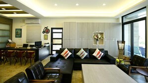 A modern living room with a sofa, chairs, a dining area, and a large window. - Mulu-Hotel (Magong)