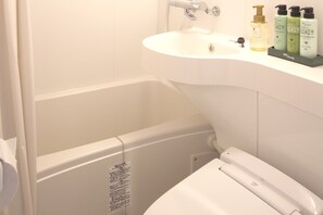 A bathroom with a white sink, a bathtub, and a toilet. There are three bottles of shampoo and conditioner on the sink. -  ARIGATO STAY KANAZAWA (Kanazawa)