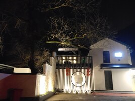 Un edificio moderno con entrada protegida por un portón, un ventanal circular y un letrero que dice "DREAM HOME".