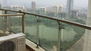 A high-rise building with a view of a river and surrounding urban area. - Arista Service Apartments Ghansoli (Navi Mumbai)