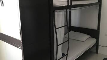 A bunk bed with a lower bunk and a top bunk, a white wardrobe, and a white door.