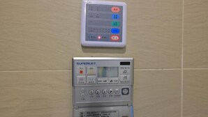 Eine wandmontierte Bedienkonsole mit digitalem Display und mehreren Tasten, vermutlich zur Verwaltung des Raumes oder der Anlage.