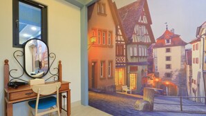 Ein Zimmer mit Schreibtisch, Stuhl und einer großen Wandmalerei einer europäischen Straßenszene.