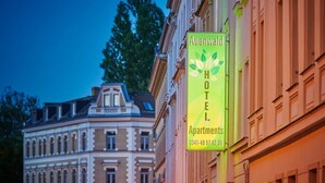 Ein Hotelschild mit dem Schriftzug 'Auenwald Hotel & Apartments' und einer Telefonnummer.