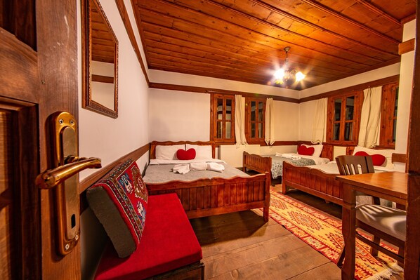 Una habitación de madera tradicional con una cama grande, una cama más pequeña y un banco.