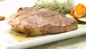 A plate with a grilled steak, rice, and grilled vegetables. - Hotel Rural Casa Migio (Mieres)