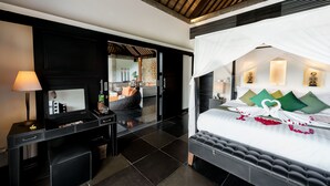 A modern hotel room with a large bed, a desk, and a mirror. - Villa Rumah Lotus (Payangan)