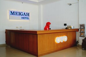 A reception desk at the Meigah Hotel with a wooden finish and a 'YOYO' sign. - Hotel Meigah (Tanjung Pandan)