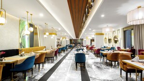 A spacious restaurant with multiple dining areas, marble flooring, and modern lighting fixtures. - The Raga Side - Adults Only - All inclusive (Manavgat)
