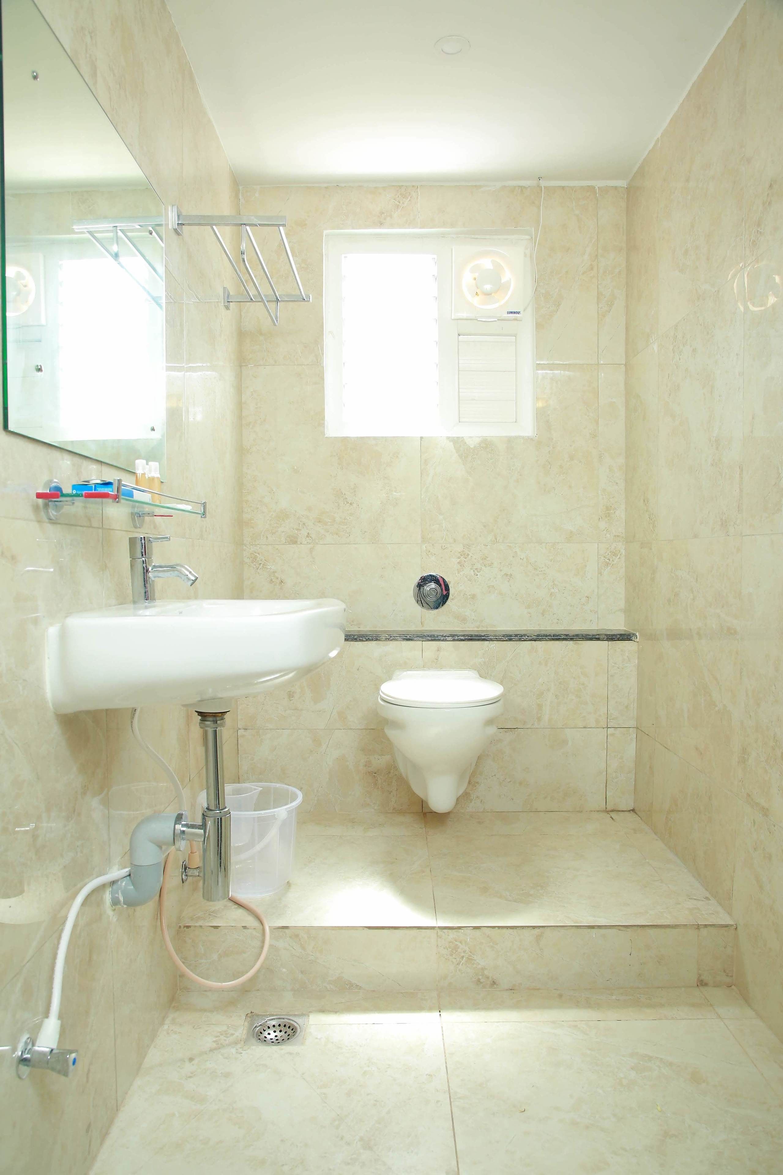 Baño con lavamanos, inodoro y zona de ducha.
