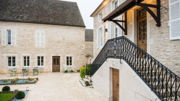A stone building with a staircase and a courtyard. - Maison Deveney Mars (Puligny-Montrachet)
