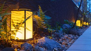 A pathway lined with rocks and a wooden fence, leading to a building with a sloped roof. - Mitsui Garden Hotel Kyoto Station (Kyoto)