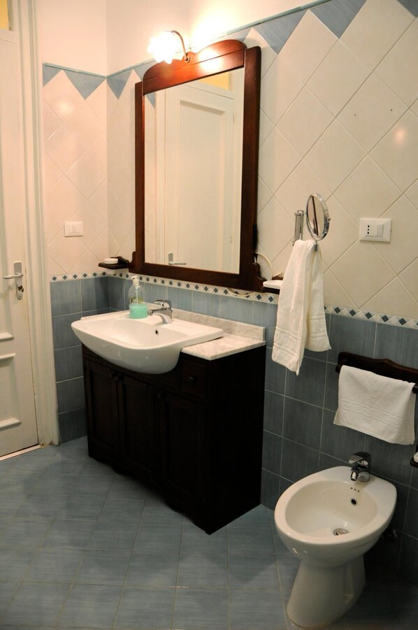 Une salle de bain avec un lavabo, un bidet et un miroir.