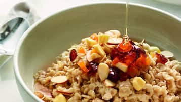 Una ciotola di porridge con noci e uvetta, condita con miele.