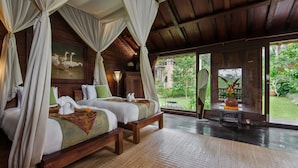 Una habitación con techo de madera, una cama con dosel y vista a un jardín.