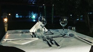 Ein Tisch für zwei Personen mit Blick auf eine beleuchtete Stadtlandschaft bei Nacht.