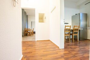 Una cocina moderna con sillas de madera y un refrigerador de acero inoxidable.