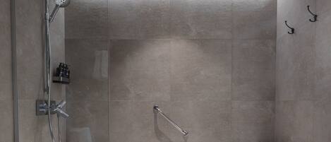A modern bathroom with a large bathtub, a glass-enclosed shower, and a separate sink area.