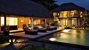 A resort with thatched-roof buildings, a swimming pool, and lounge chairs. - Villa Kelusa Ubud (Payangan)