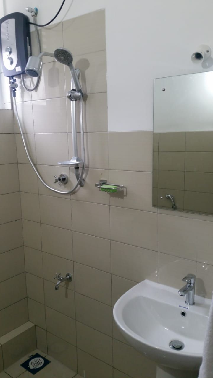 Un baño con ducha, lavabo y espejo.
