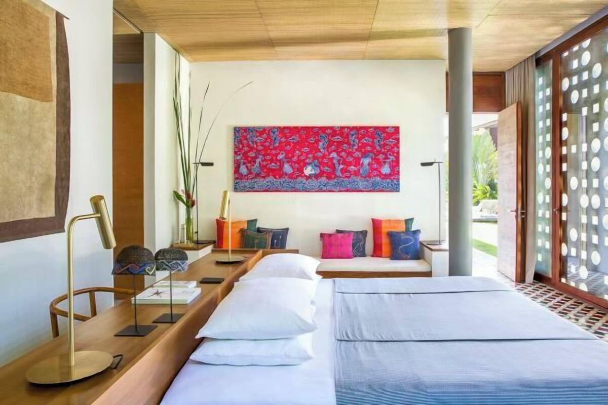 Una habitación moderna con una cama, un escritorio y un ventanal grande.