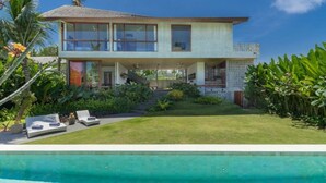 Una casa de dos pisos con piscina delantera.