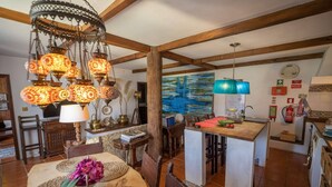 A rustic dining area with a wooden table, woven placemats, and a hanging light fixture.