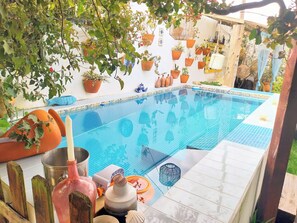 Piscine extérieure en saison, parasols, chaises longues
