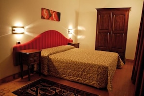 A bedroom with a bed, bedside tables, a wardrobe, and wall-mounted lights. - Hotel Al Barco (Santo Stino di Livenza)