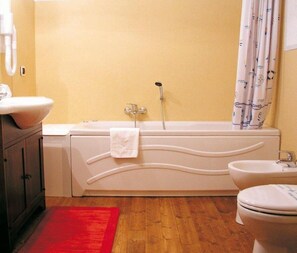 A bathroom with a bathtub, a toilet, and a bidet. - Hotel Al Barco (Santo Stino di Livenza)