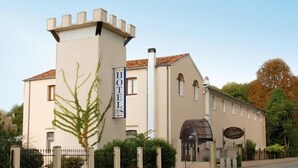 Un hotel con una estructura similar a una torre, un cartel que indica que es un hotel y un restaurante visible llamado "Hotel Restaurant".