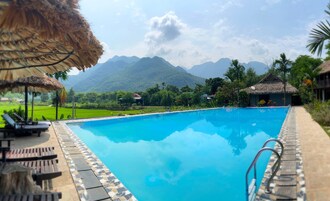 Una piscina al aire libre, sombrillas, tumbonas