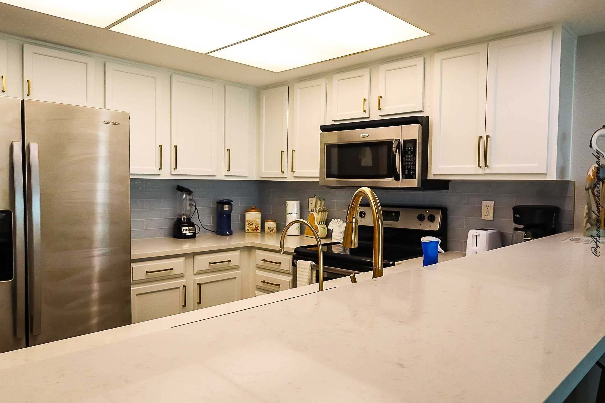 Una cocina moderna con gabinetes blancos, electrodomésticos de acero inoxidable y una isla grande.