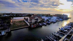 A marina with boats docked, a waterfront promenade, and buildings along the shore.