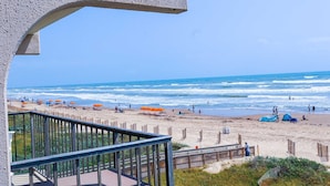 A beach with umbrellas, people, and tents. - Florence I 307 Minium 1 Bedroom Condo by RedAwning (South Padre Island)