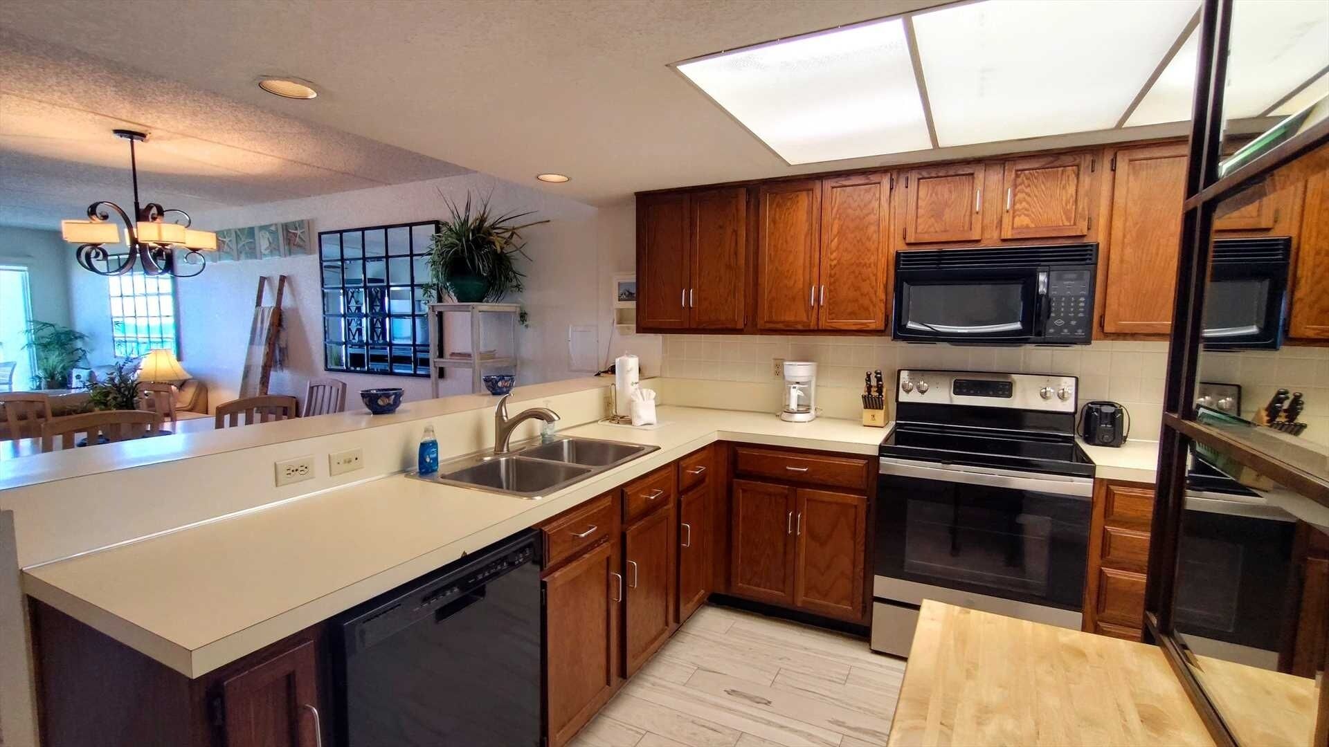 A modern kitchen with wooden cabinets, a dishwasher, a stove, and a microwave.