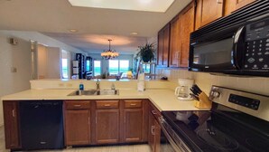 A modern kitchen with wooden cabinets, a dishwasher, a stove, and a microwave.