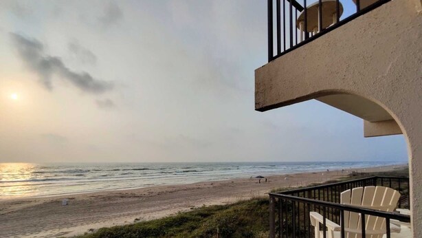 Un balcón con vista a la playa y al océano.